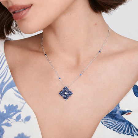 Approx.&nbsp;2.40 carats Round&nbsp;Blue Sapphires
White Diamond Center
Pendant Set in 18K White and Black Gold
Color Stone Chain Included
Pendant Measures: 17mm X 17mm
Necklace Measures: 18 inches