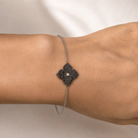 0.86 carats Round Black Diamonds
0.04 carats&nbsp;Center Round White Diamond
Bracelet&nbsp;Set in 18K White Gold
Flower Motif: 12mm X 12mm
Bracelet Length 6.75 inches