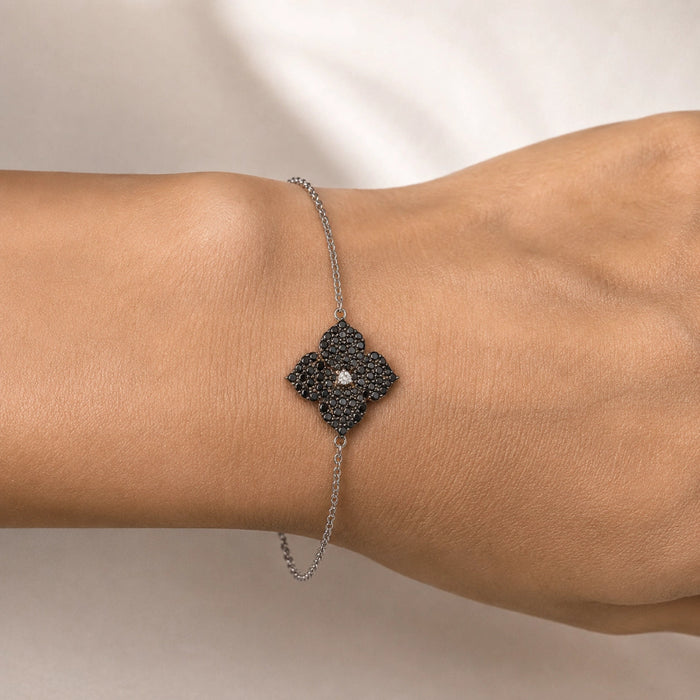 0.86 carats Round Black Diamonds
0.04 carats&nbsp;Center Round White Diamond
Bracelet&nbsp;Set in 18K White Gold
Flower Motif: 12mm X 12mm
Bracelet Length 6.75 inches